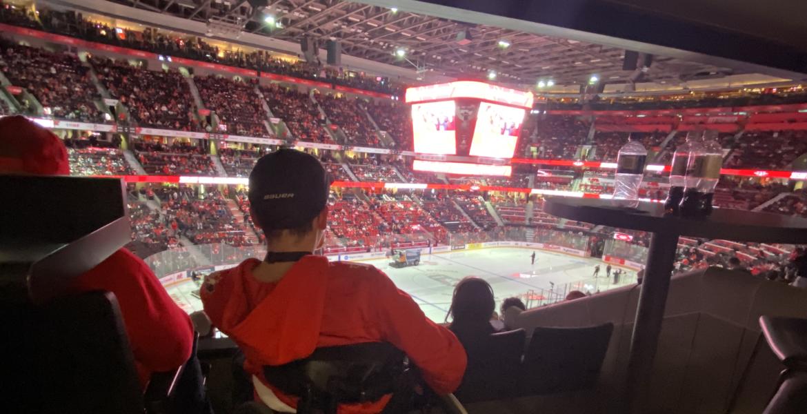 Kingsley watches the World Juniors Game from his wheelchair surrounded by fans in red